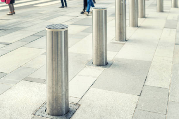 Stainless steel bollard entering pedestrian area on Vienna city street. Car and vehicle traffic access control.